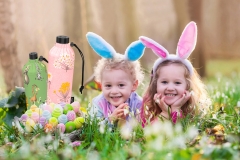 Kids on Easter egg hunt in blooming spring garden