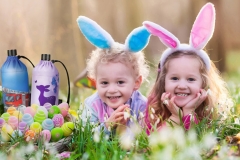 Kids on Easter egg hunt in blooming spring garden