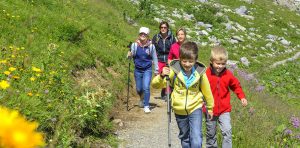 Kinder wandern mit ihren Eltern auf einem Wanderweg