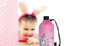 Ein Kind schaut über den Tisch und sieht einen rosa Emil Trinkflasche, auf der ein Einhorn abgebildet ist. Das Mädchen hat einen Haarreif mit Hasenohren auf dem Kopf.
